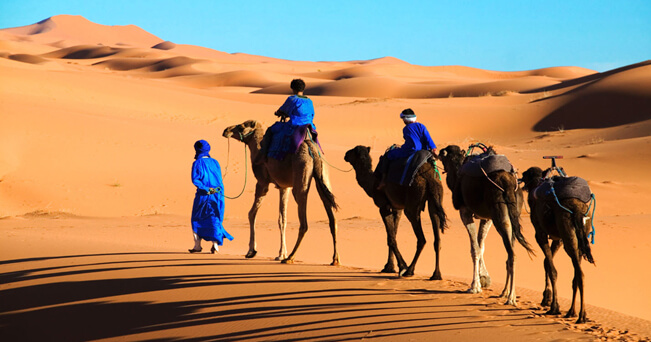 Un Tuareg e i suoi bambini attraversano l'area di Erg Chebbi nel deserto del Sahara (foto Martin Harvey / Alamy / Milestone Media)