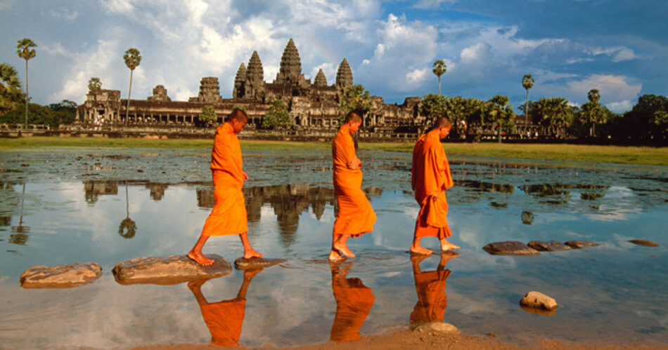AJ7671 Monks walking past the reflection of Angkor Wat, Angkor, Cambodia